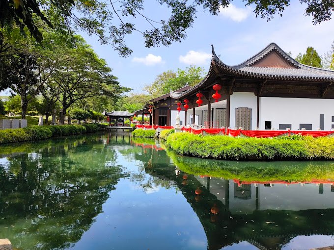 Traditional memorial architecture reflected beside a pond at Nirvana Semenyih