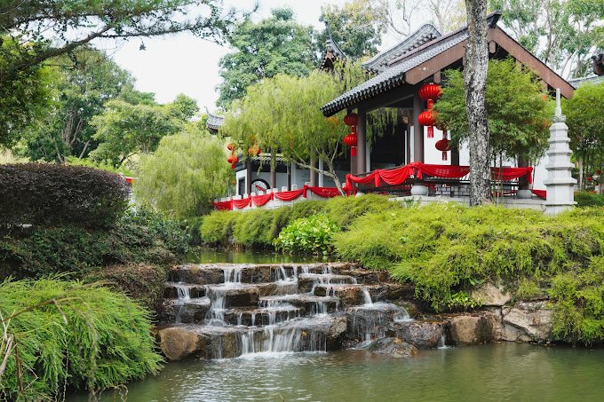 Tiered waterfall below a traditional pavilion in the Shi Wai Tao Yuan garden