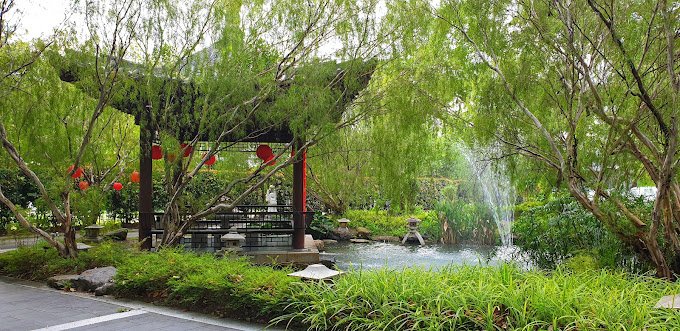 Landscaped pond and pavilion surrounded by willow trees at Nirvana Shah Alam