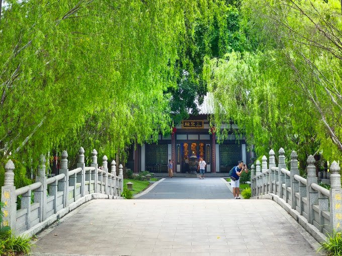 Stone bridge beneath willow trees within Nirvana Shah Alam
