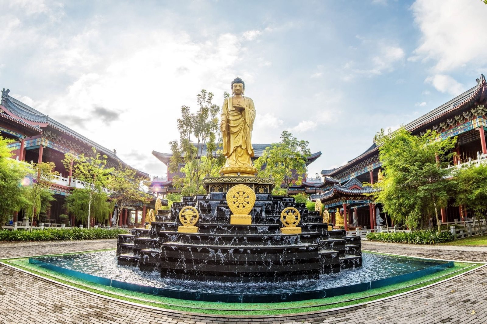 Palatial Chinese-style memorial courtyard centred on a golden Buddha statue and fountain
