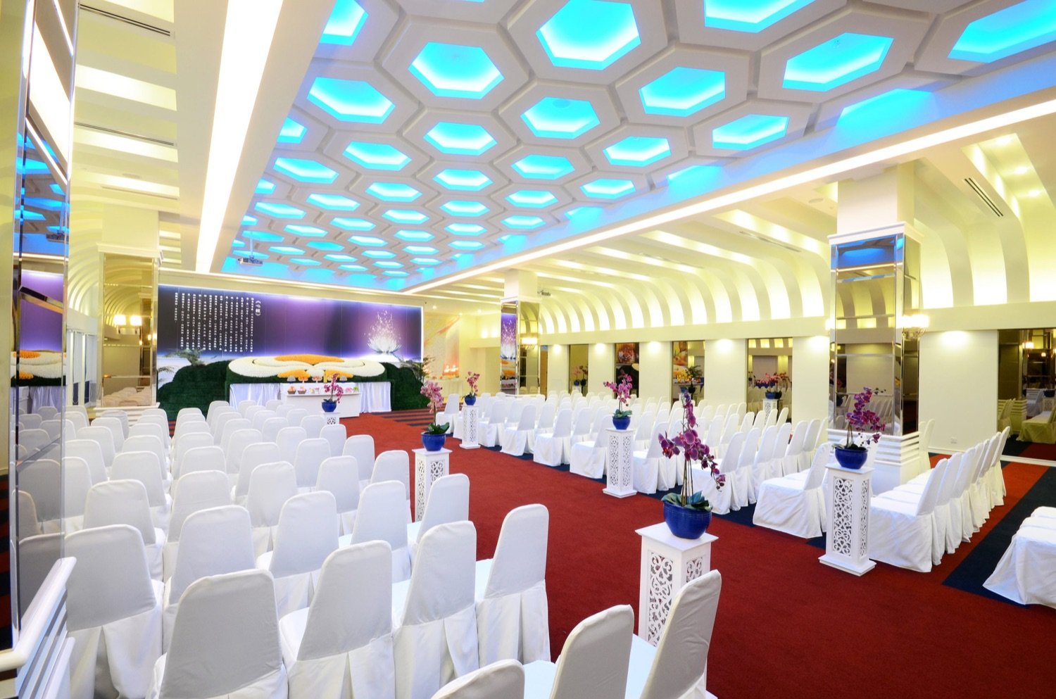Large memorial parlour with extensive seating and a ceremonial stage
